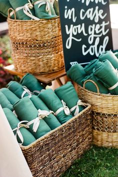 baskets filled with green towels sitting on top of a grass covered field next to a sign