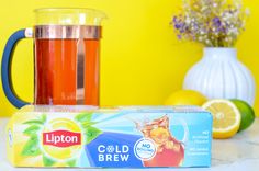 a box of lipton cold brew next to a cup of tea and some lemons