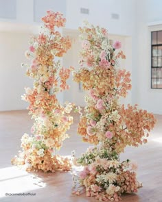 two vases filled with flowers on top of a wooden floor