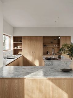 a kitchen with marble counter tops and wooden cabinets