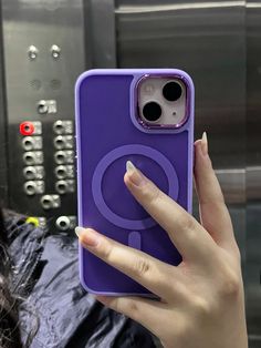 a woman holding up her purple phone case with the letter q on it's back