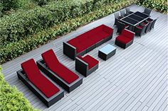 an outdoor seating area with red and black furniture on the ground next to shrubbery