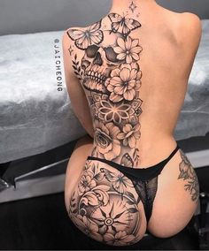 the back of a woman's body with tattoos and flowers on her butts