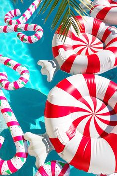 inflatable candy canes and palm trees are floating on the blue pool water