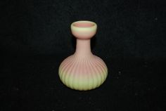 a pink vase sitting on top of a black table