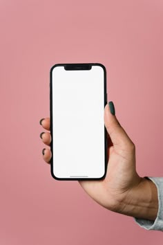 a person holding up a cell phone with a white screen in their hand on a pink background