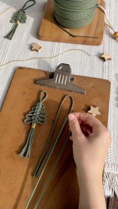 someone is working with string and scissors on a crafting project that includes green twine