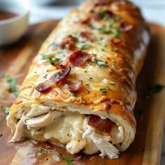 a close up of a pastry on a cutting board with meat and cheese in it