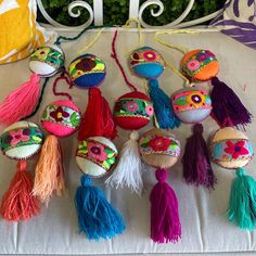 many colorful objects are on display on a white tablecloth with green plants in the background