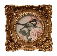 a small gold frame with a bird and flowers on the inside, in front of a white background