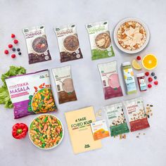 an assortment of healthy food items laid out on a white surface with fruit and vegetables