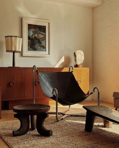 a living room filled with furniture and a painting hanging on the wall above an umbrella