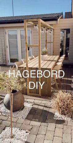 a wooden table sitting on top of a brick patio next to a building with the words hagebord diy written over it