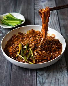 a white bowl filled with noodles and vegetables