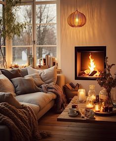 a living room filled with furniture and a fire place next to a large window on top of a wooden floor