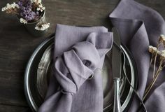 a place setting with napkins, silverware and flowers