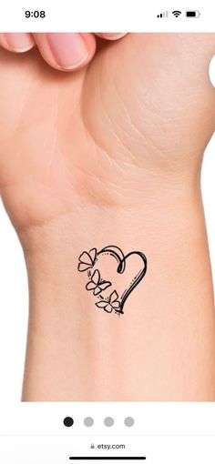 a small heart tattoo on the wrist