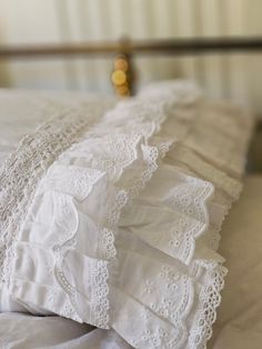 an image of white linens and lace on a bed