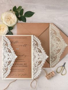 the wedding stationery is laid out on top of an envelope with lace and flowers