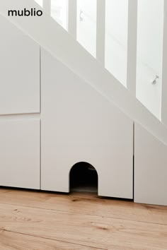 a dog house under the stairs with its door open