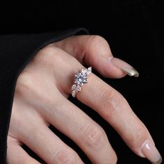 a woman's hand with a diamond ring on it