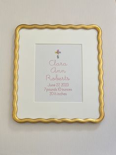 a white and gold frame with a baby's birth date on the front in pink