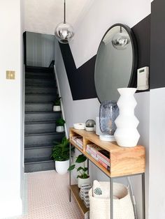 there is a mirror and vase on the table in this room with black and white walls