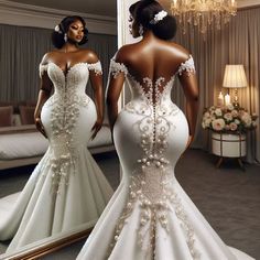 a woman in a white wedding dress looking at herself in the mirror with her back to the camera