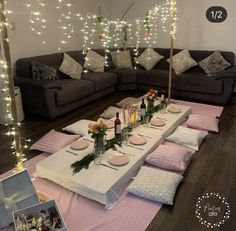 a table set up for a party with candles, plates and flowers on the table