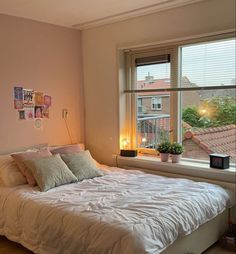 a white bed sitting next to a window in a room with lots of light on it