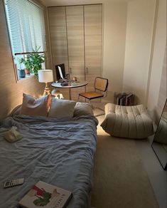 a bed sitting in a bedroom next to a window with blinds on the windowsill