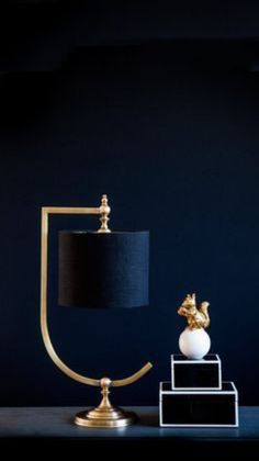 a table lamp with a black shade on it and a white marble ball in the middle