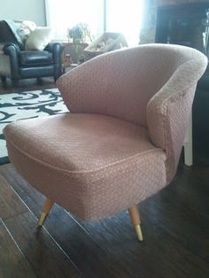 a pink chair sitting on top of a hard wood floor