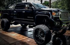 a black truck parked on top of a wooden floor