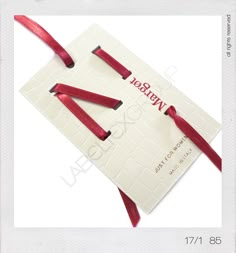 a white card with red ribbon tied around it