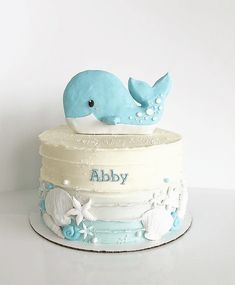 a baby whale cake with blue and white icing on it's bottom layer