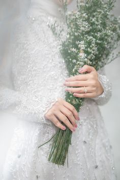 a woman in a wedding dress holding flowers