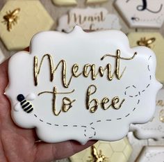 a hand holding a white and gold magnet with the words meant to bee on it