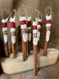 five cinnamon stick santa clause ornaments in a holder