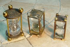 three antique brass and glass lanterns sitting on a tile floor