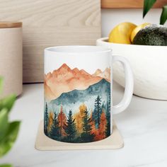 a coffee mug sitting on top of a counter next to a bowl of lemons