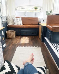 a person laying on the floor in front of a camper with lots of furniture