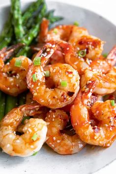 a white plate topped with shrimp and asparagus