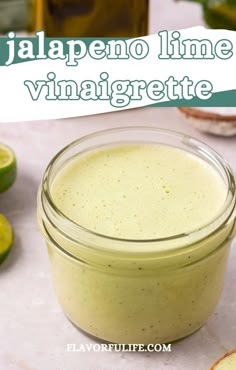 a jar filled with green liquid next to sliced limes