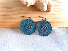 "Copper metal and turquoise color dangle drop earrings. Dimensions: circle, 1.25\" inches around, total drop length: 2\" inches." Turquoise Circle Earrings Gift, Blue Metal Jewelry, Nickel-free Turquoise Circle Jewelry, Nickel-free Blue Circular Earrings, Blue Nickel-free Round Earrings, Nickel-free Blue Earrings, Metal Drop Earrings With Patina, Turquoise Metal Round Hoop Earrings, Turquoise Dangle Earrings With Patina