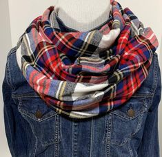 a blue jean jacket with a red, white and black plaid scarf draped over it