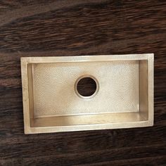 a square shaped metal object on a wooden surface