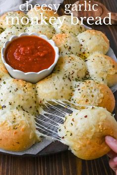 homemade garlic bread rolls on a plate with a fork and dipping sauce in the middle