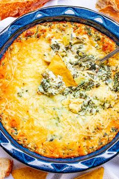 a blue bowl filled with cheese and tortilla chips on top of a table