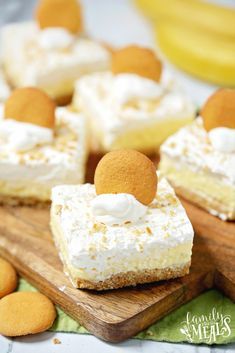 banana cream pie bars with marshmallow toppings on a cutting board and bananas in the background